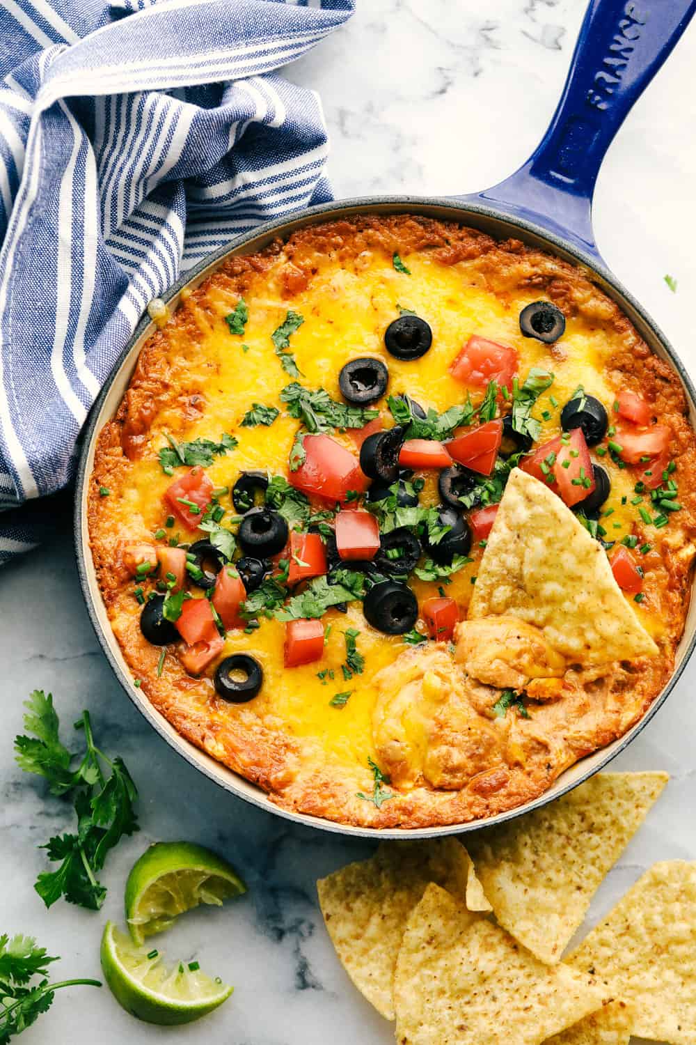 Bean dip in a blue cast iron pan with chips.