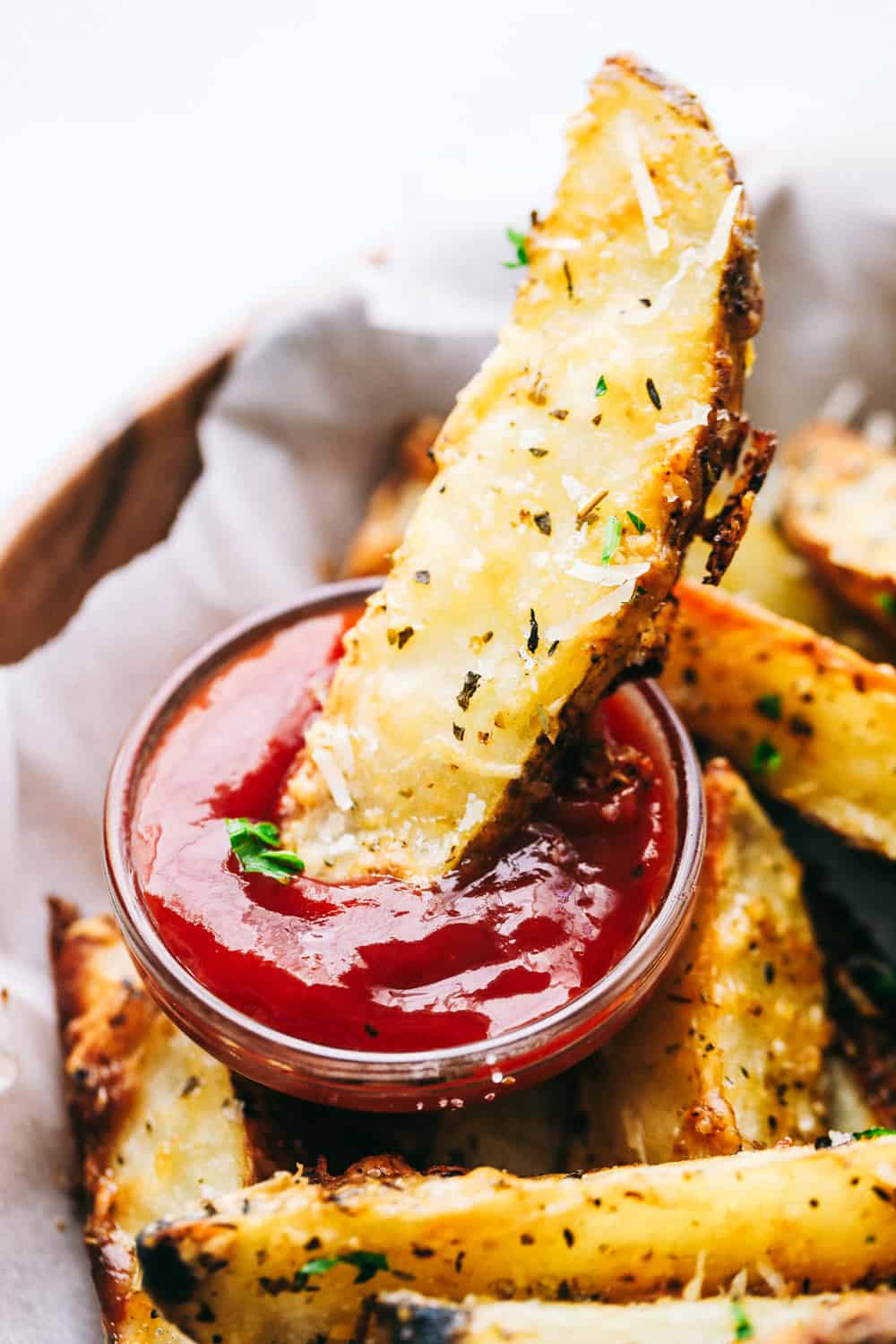 Dipping a potato wedge in ketchup.