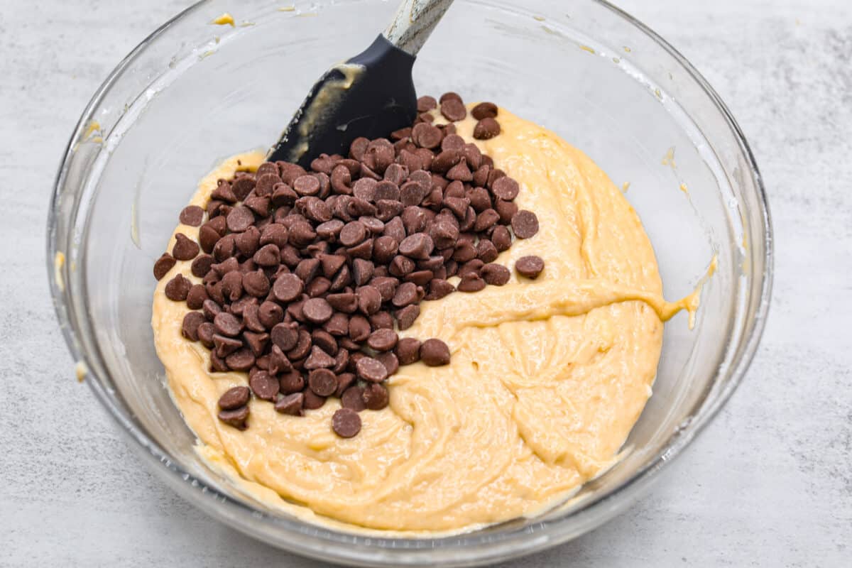 Chocolate chips being folded into batter. 