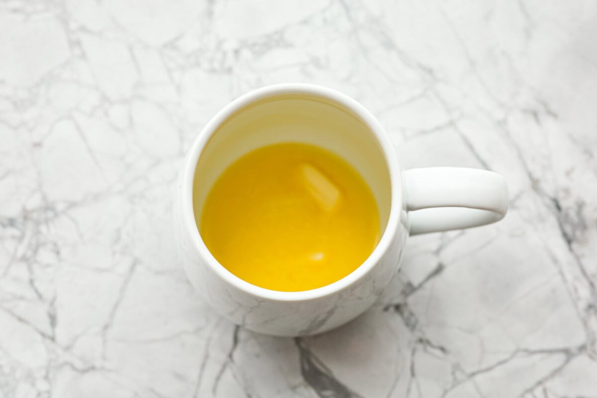 Overhead shot of butter melted in a mug. 