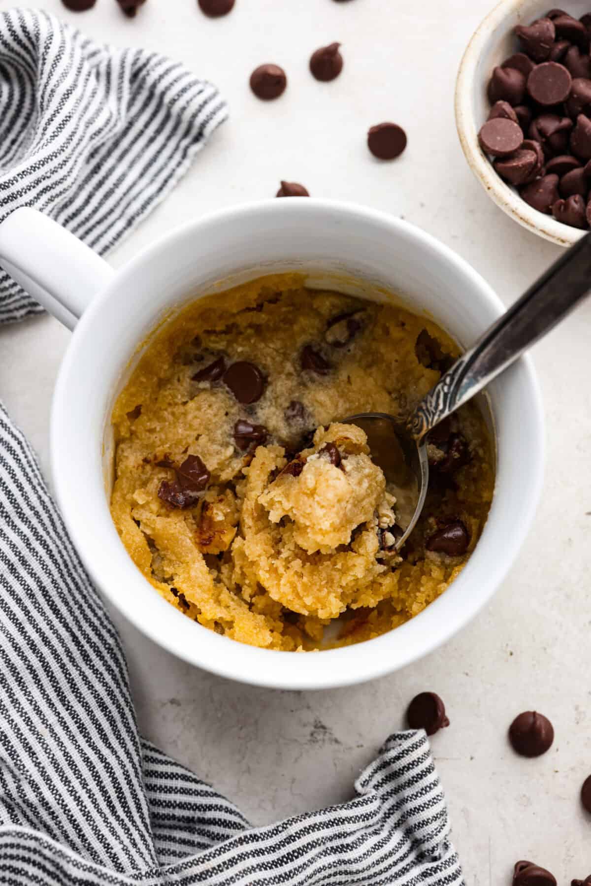 Overhead shot of cookie in a mug with spoon. 