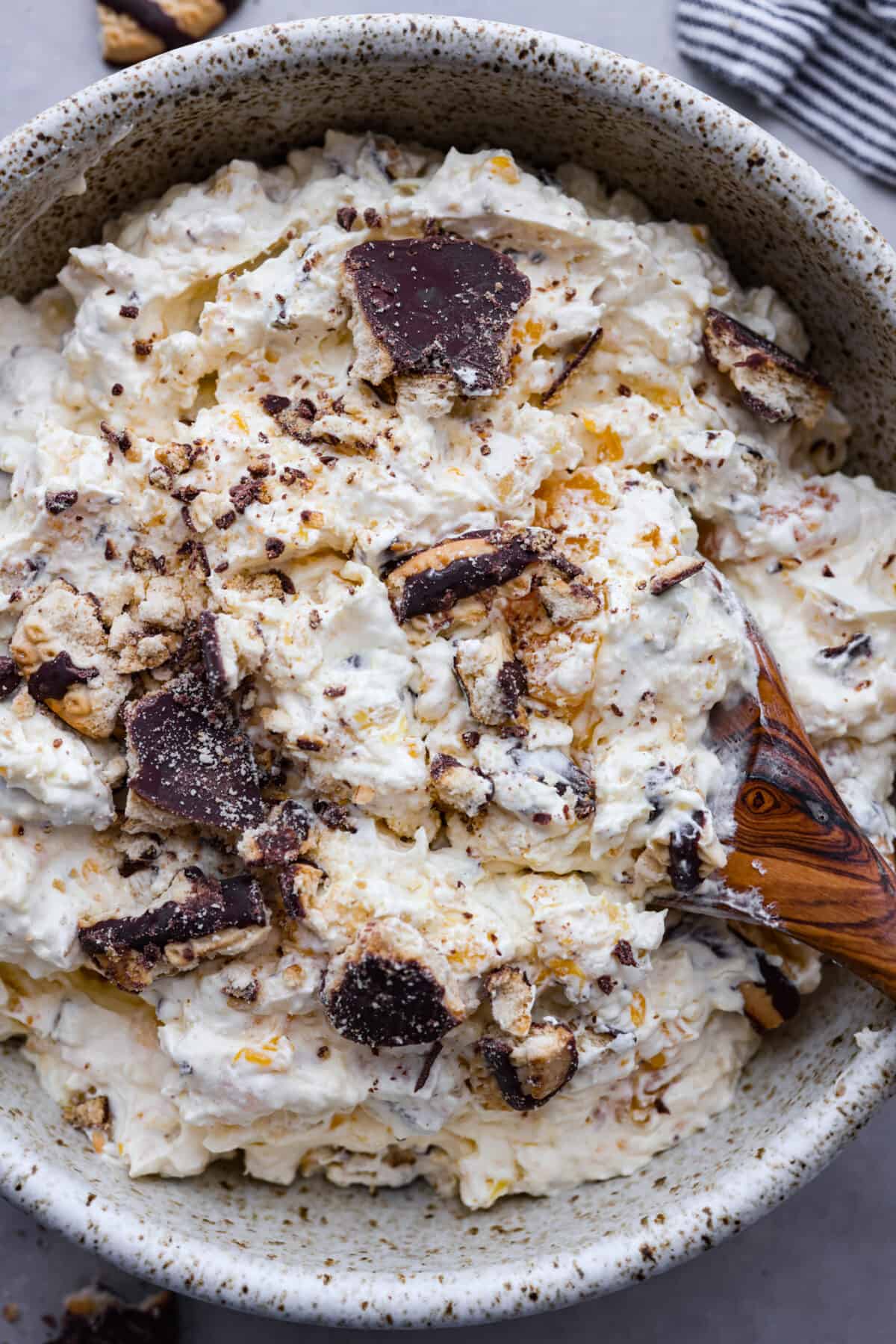 Top close view of cookie salad in a bowl with a wood serving spoon.