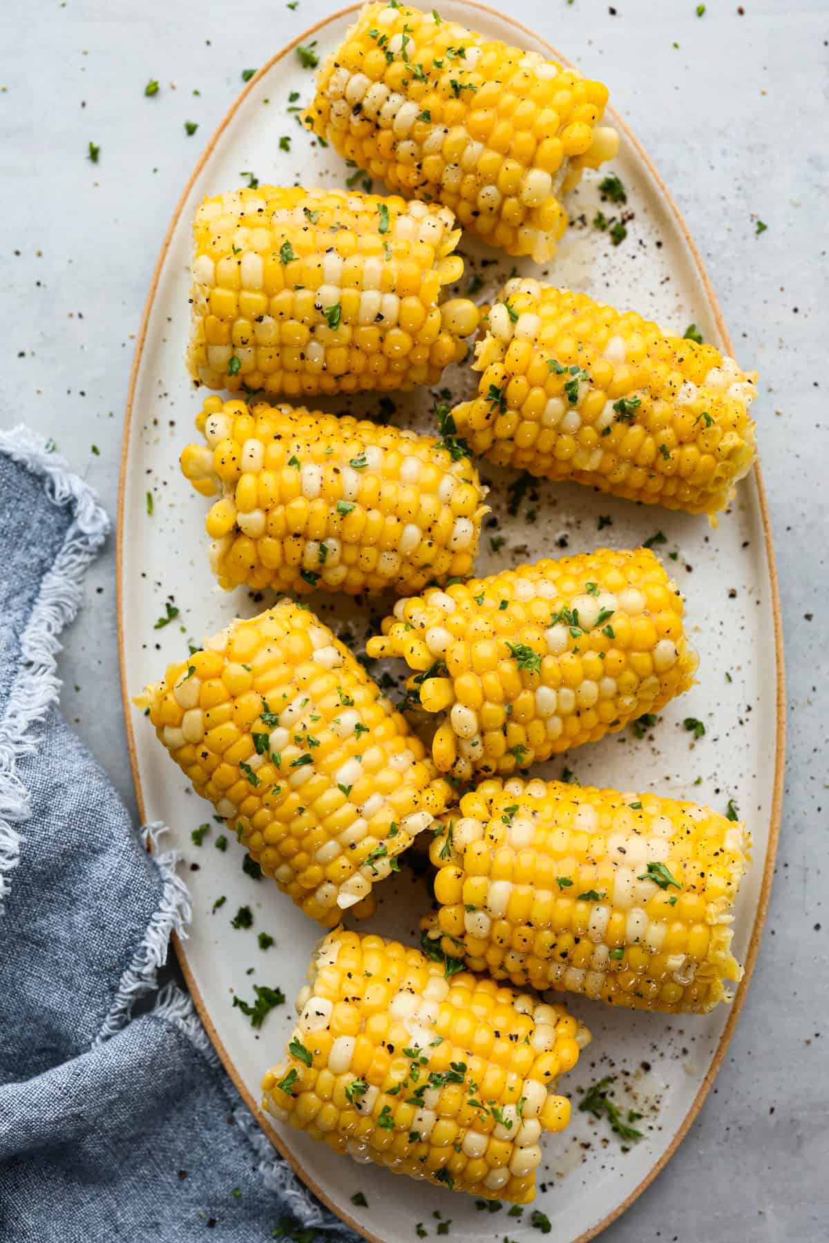 Top view of corn on the cob on a platter garnished with cilantro.