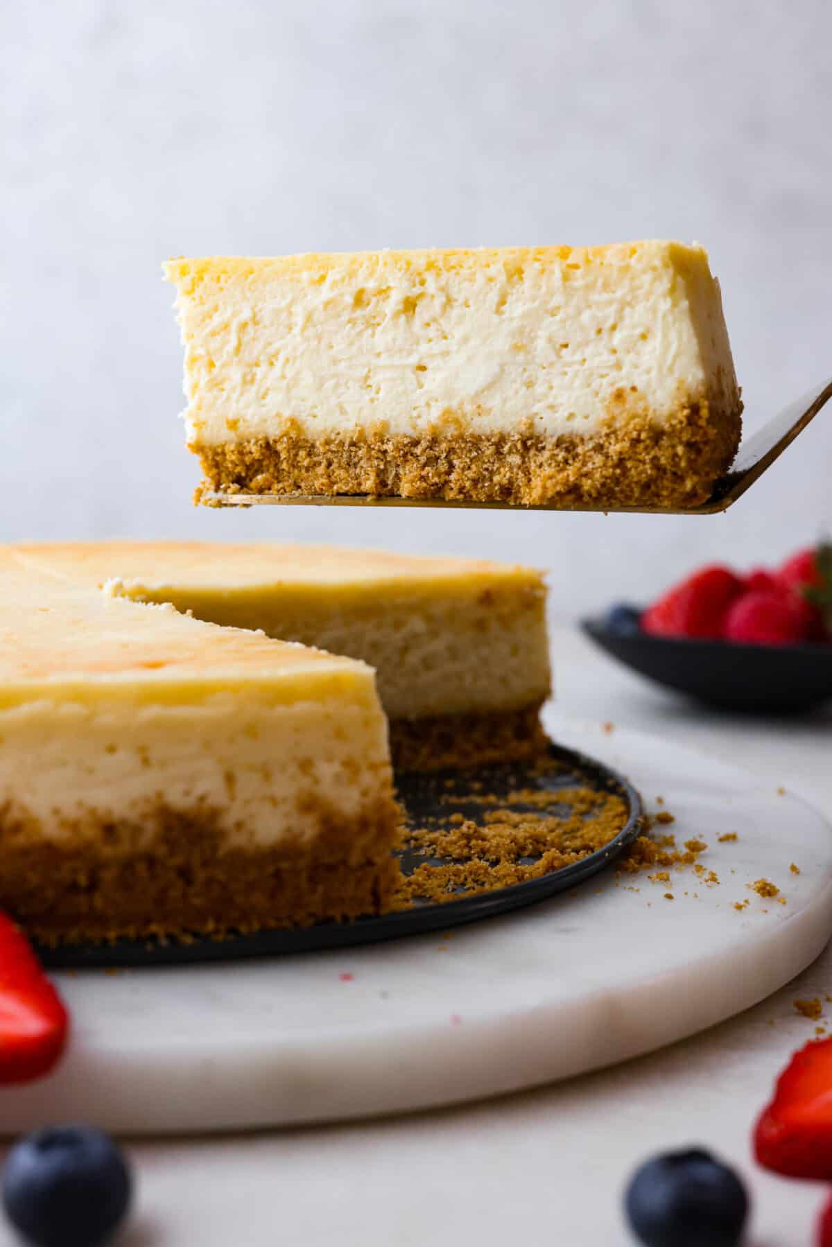 Close view of a slice of cheesecake lifting.