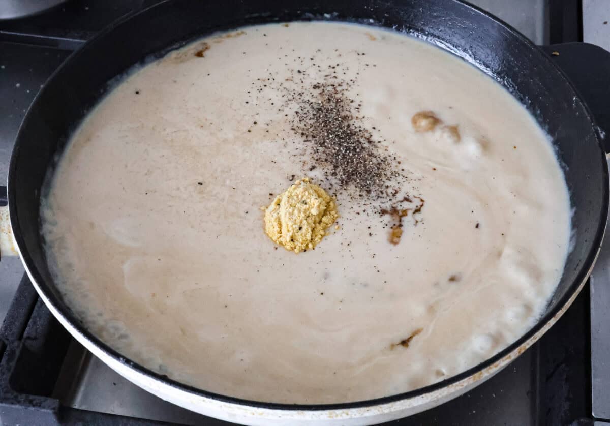 Overhead hot of cream and seasonings in the skillet. 