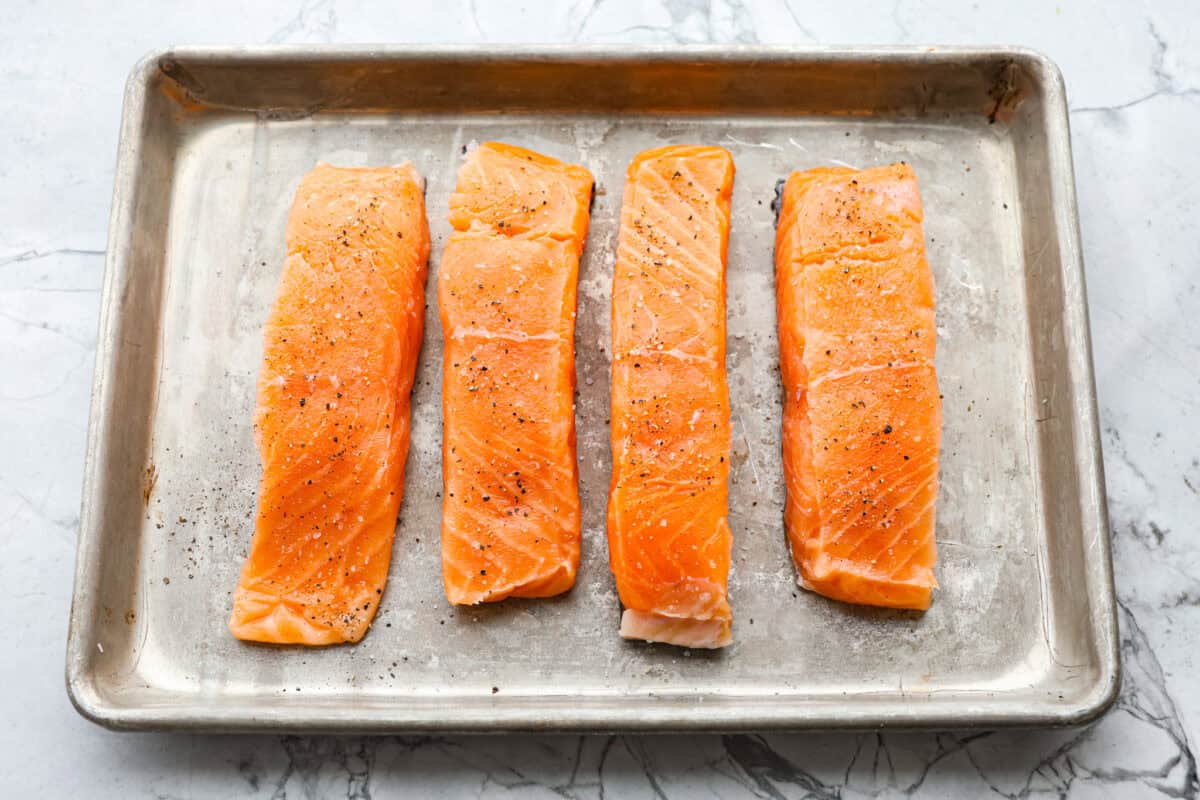 Overhead shot of salmon filets on a baking sheet. 