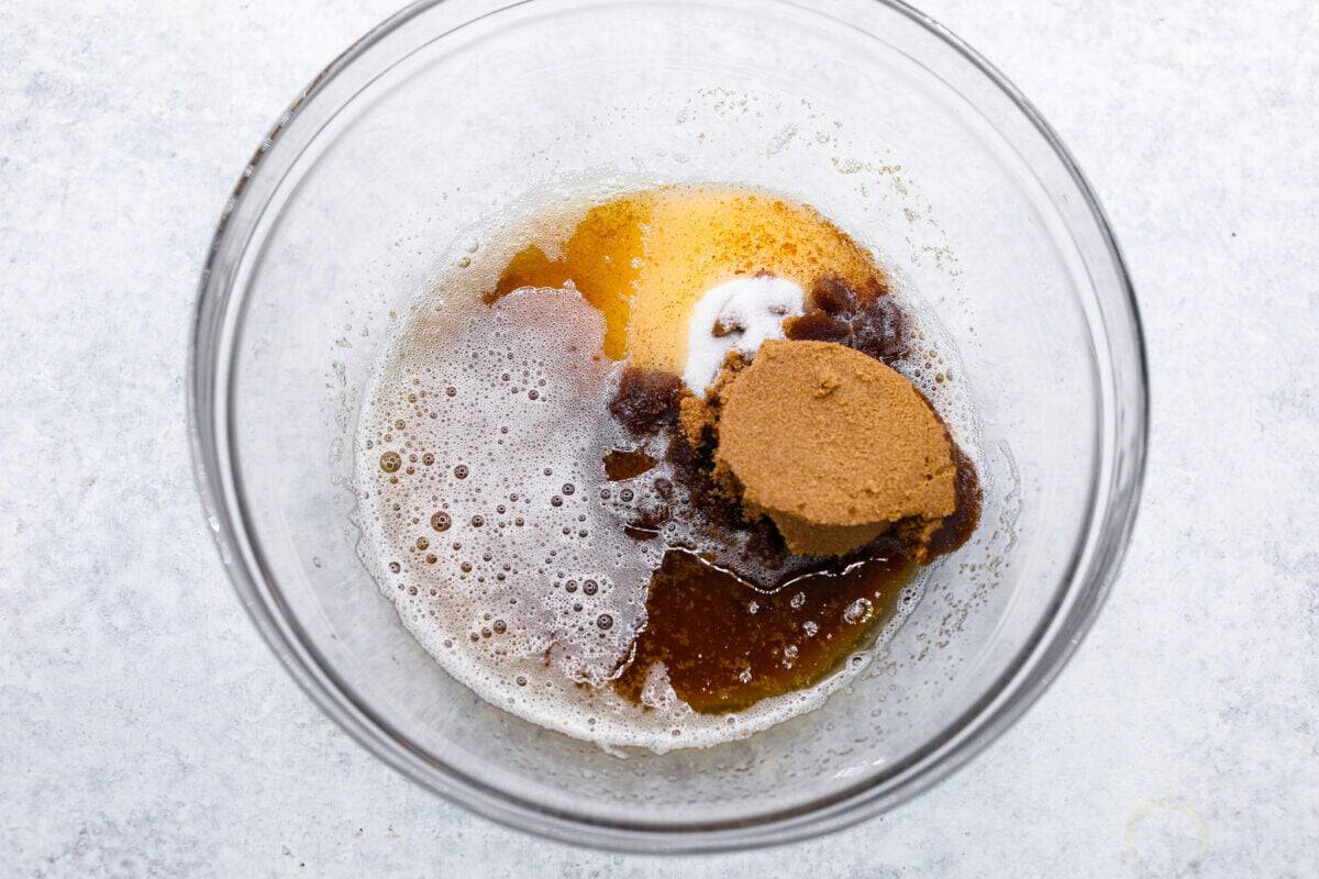 Overhead shot of brown sugar, granulated sugar, browned butter in a glass bowl. 