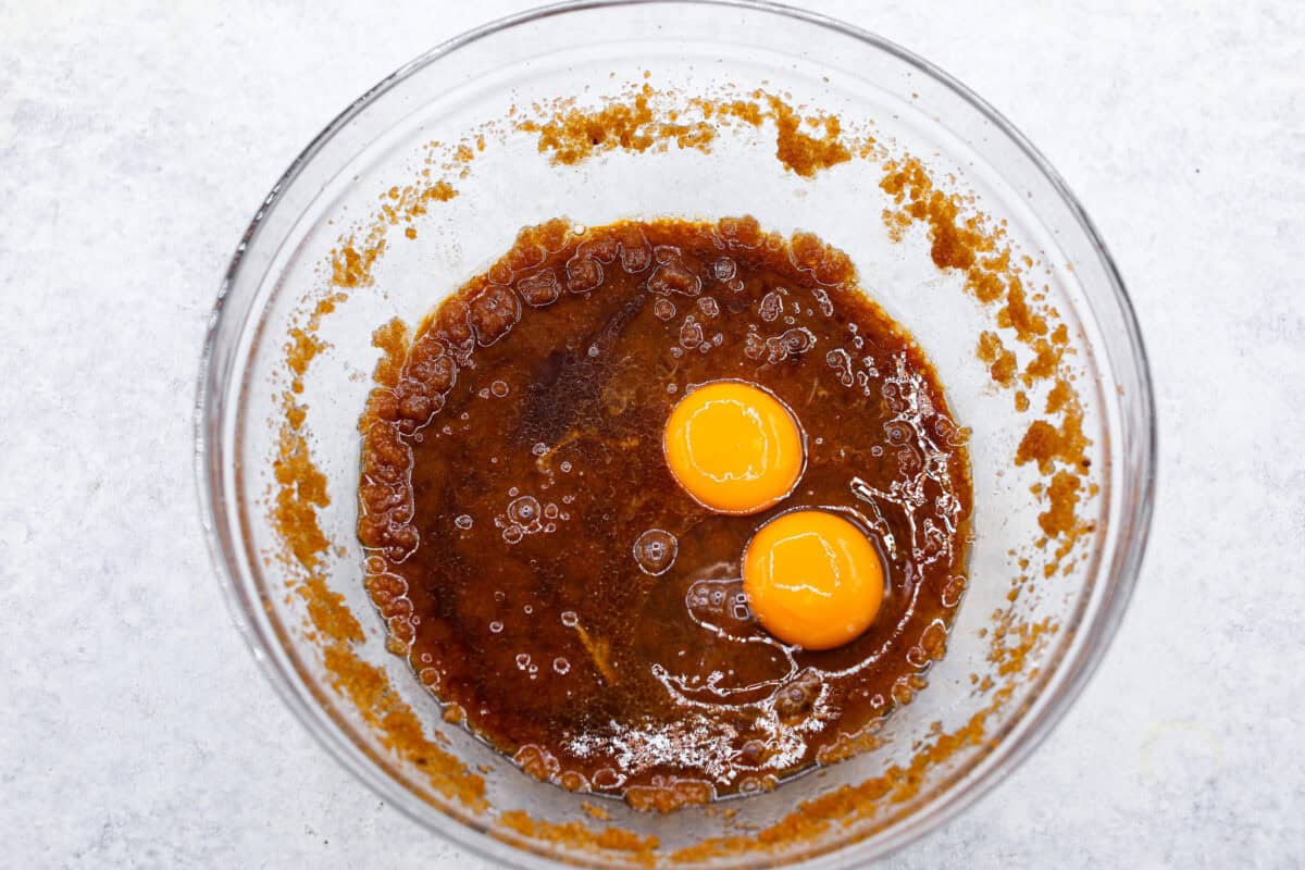 Overhead shot of sugar and butter mixture with egg and egg yolk on top. 