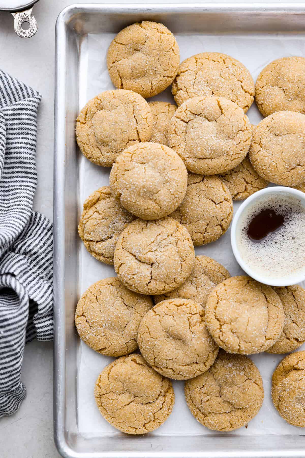 Overhead shot of browned butter sugar cookies stacked on a cookie sheet. 