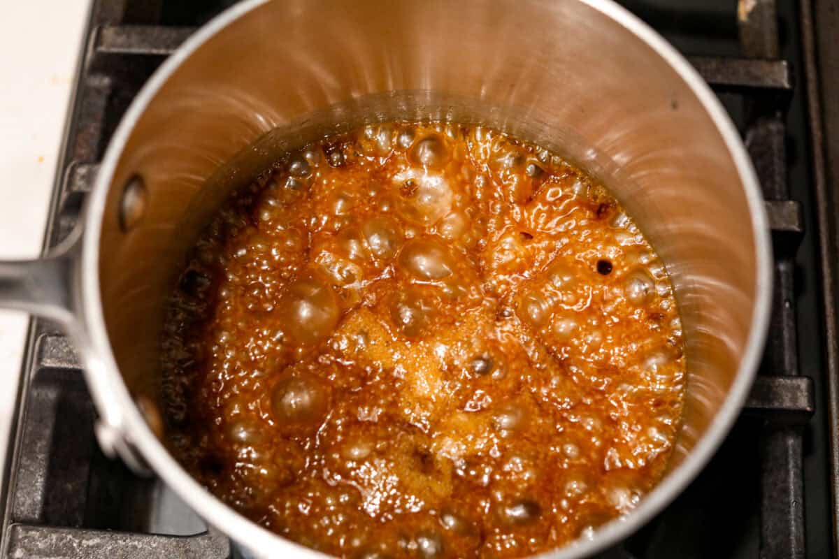 Overhead shot of sugar and butter mixture boiling in a saucepan. 