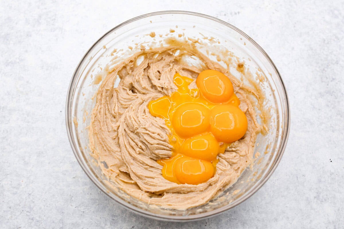 Overhead shot of crack pie filling with egg yolks in a glass bowl. 