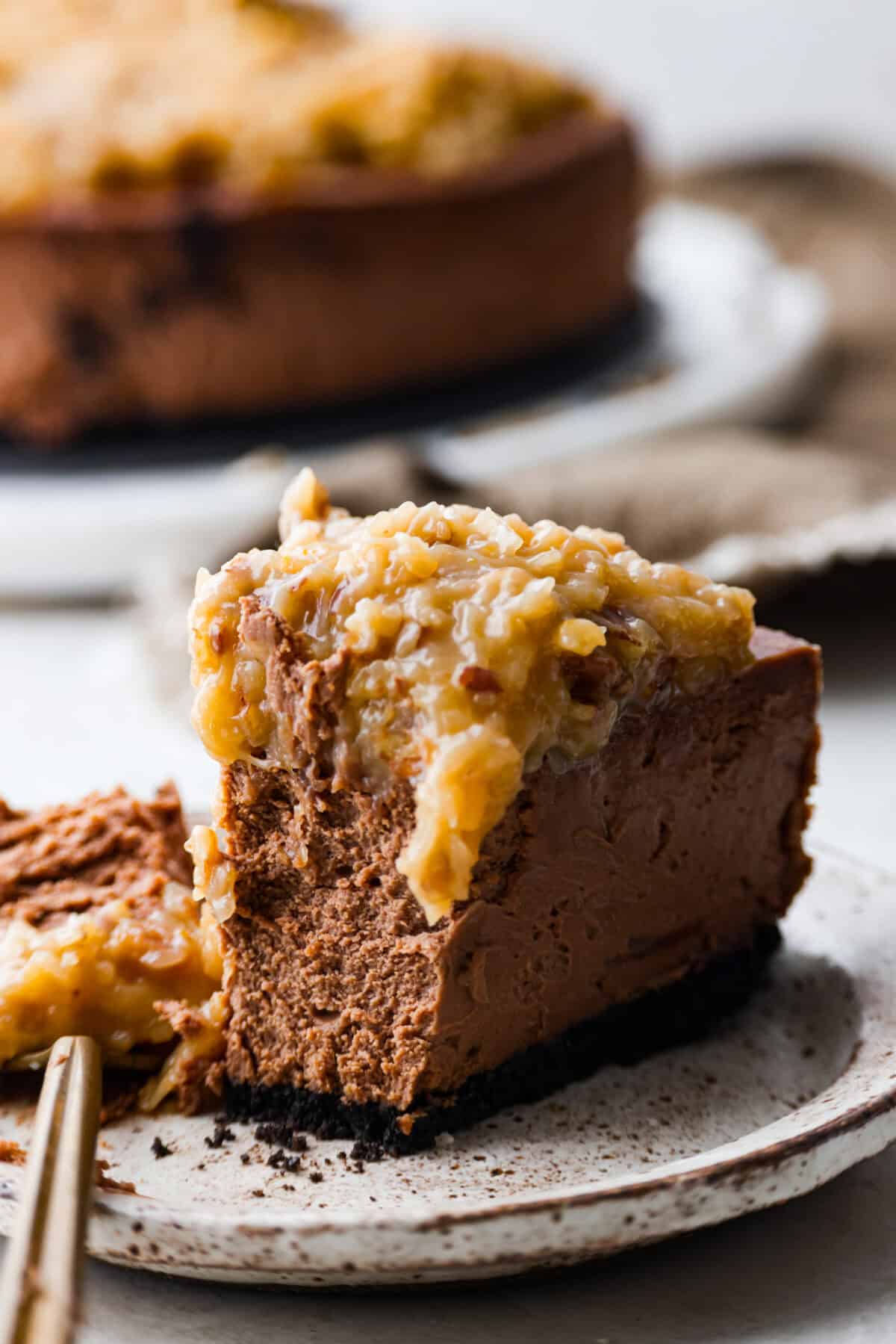 Close view of a slice of German chocolate cheesecake on a plate.