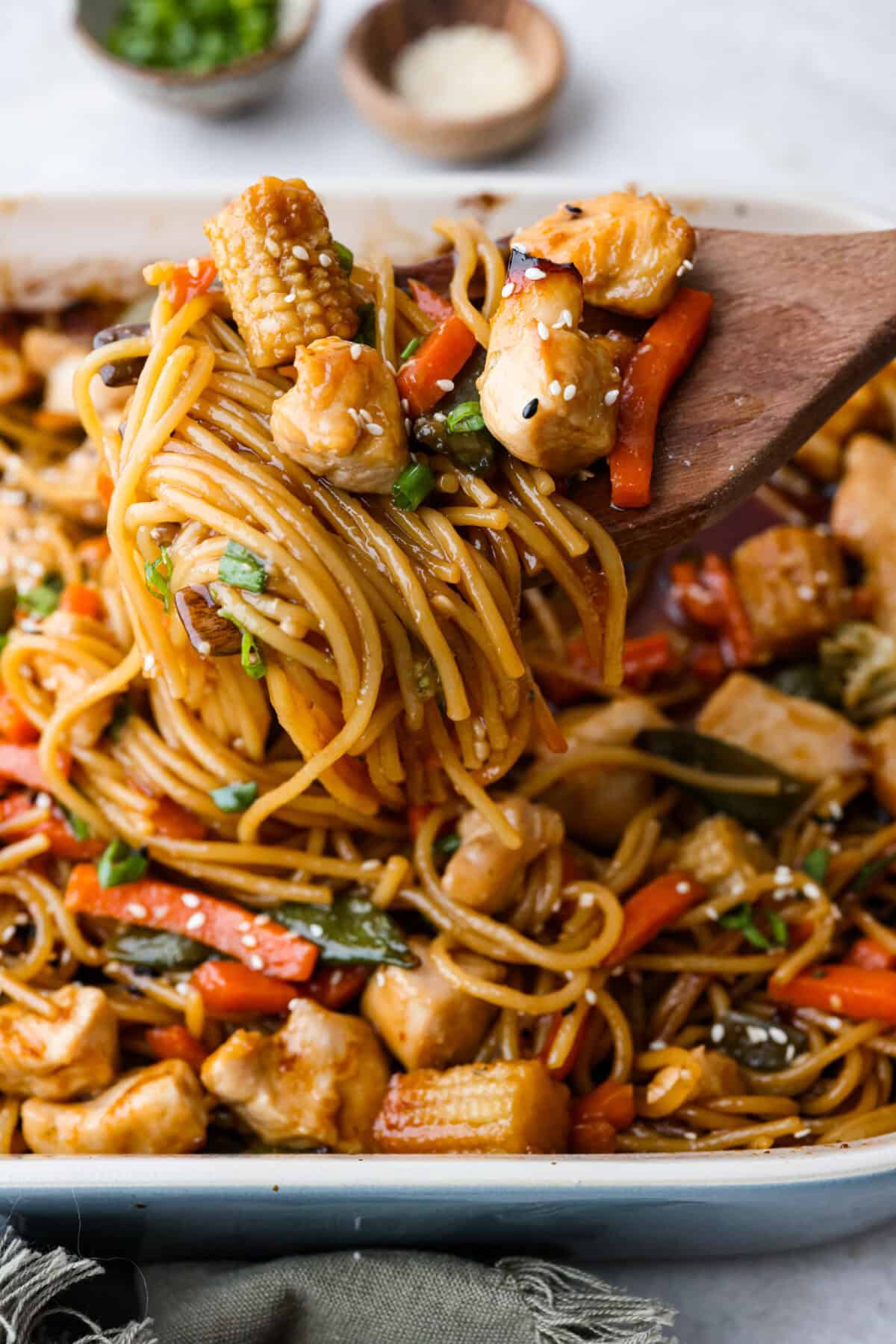 Close up shot of a scoop of honey sesame chicken noodle bake. 