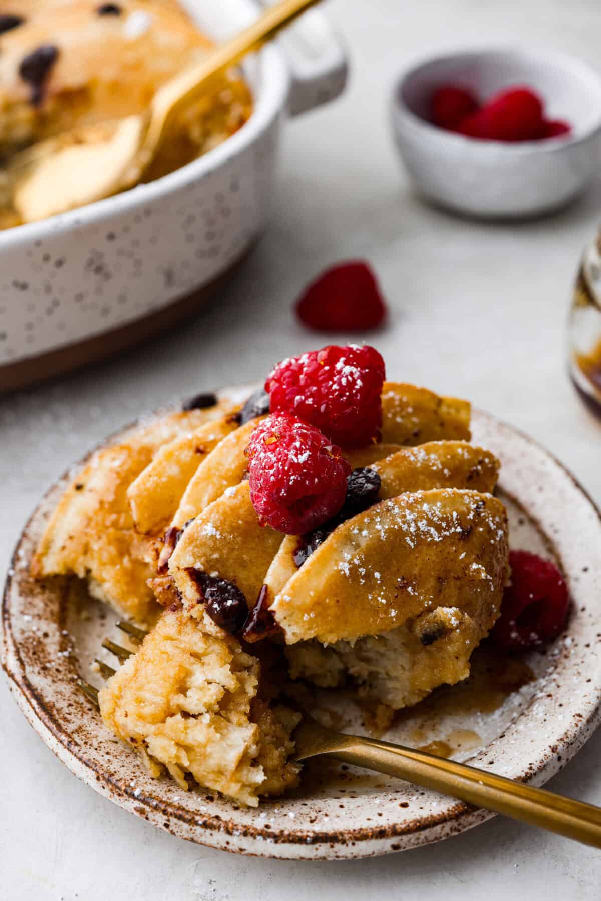 Angle shot of plated casserole with berries on top. 