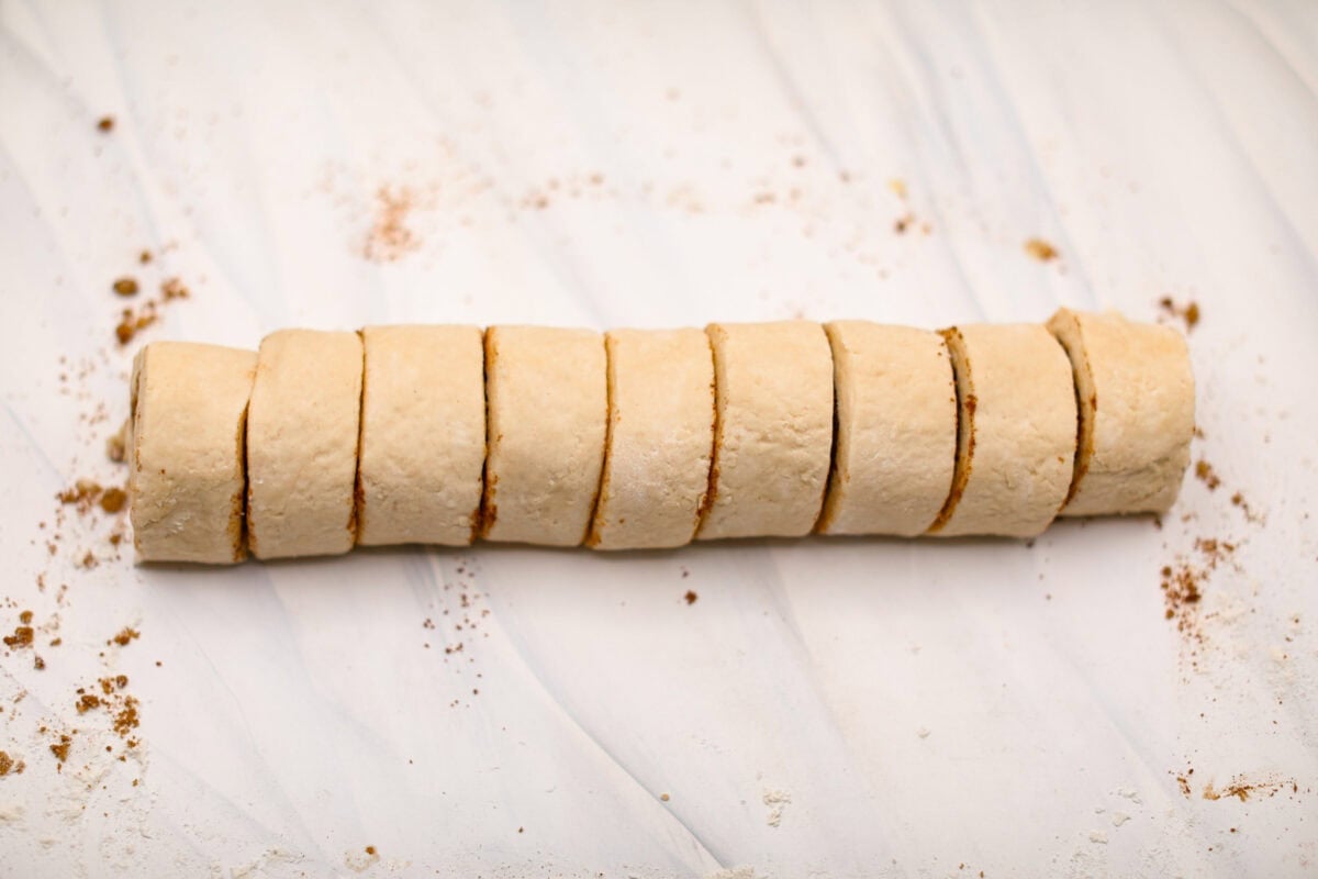 Overhead shot of cylinder having been cut into individual biscuit cinnamon rolls. 