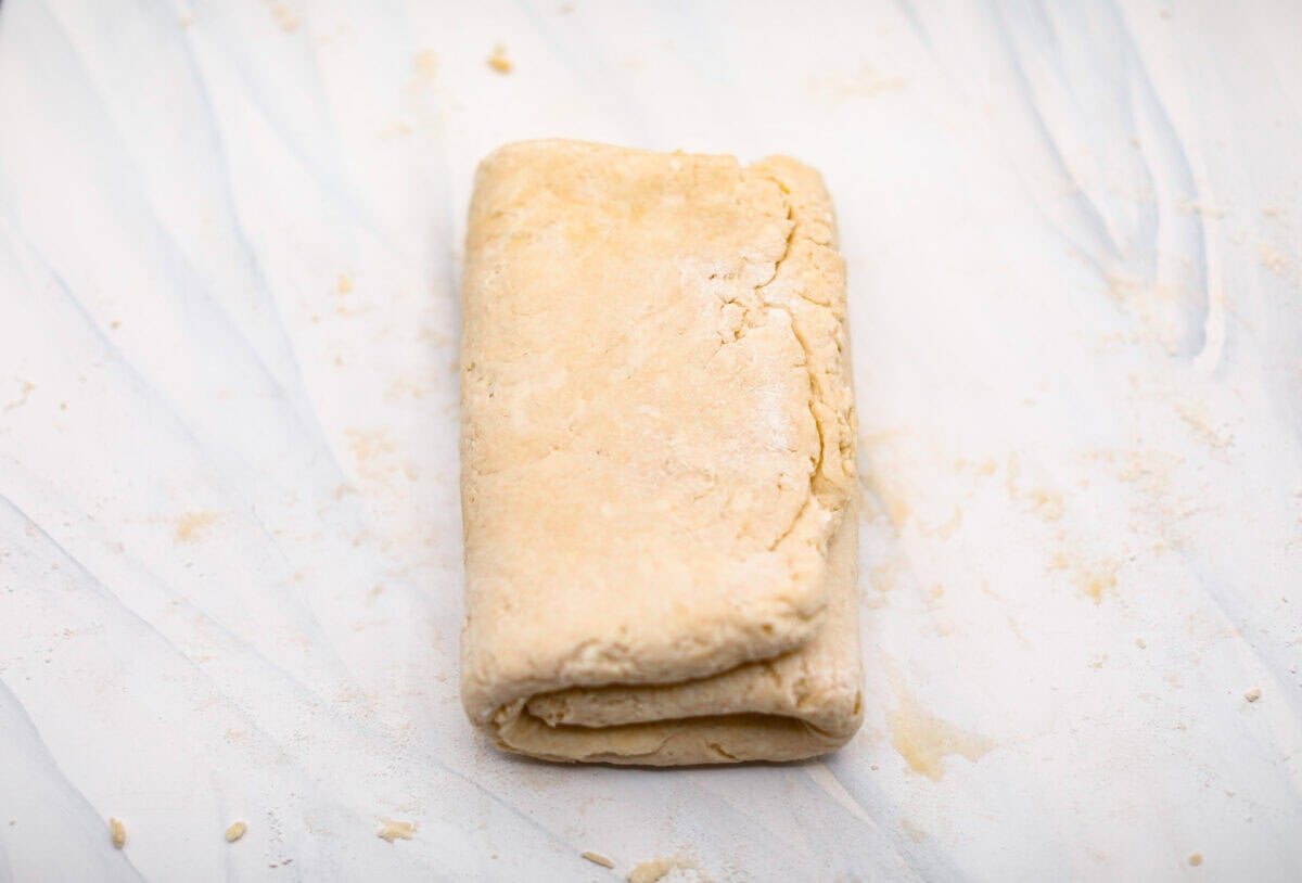 Overhead shot of biscuit dough folded into a tri-fold. 