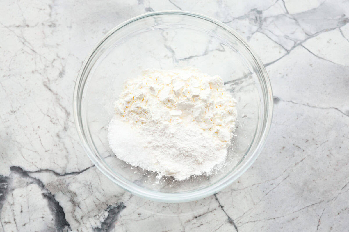 Overhead shot of the cornstarch, salt and baking powder in a glass bowl. 