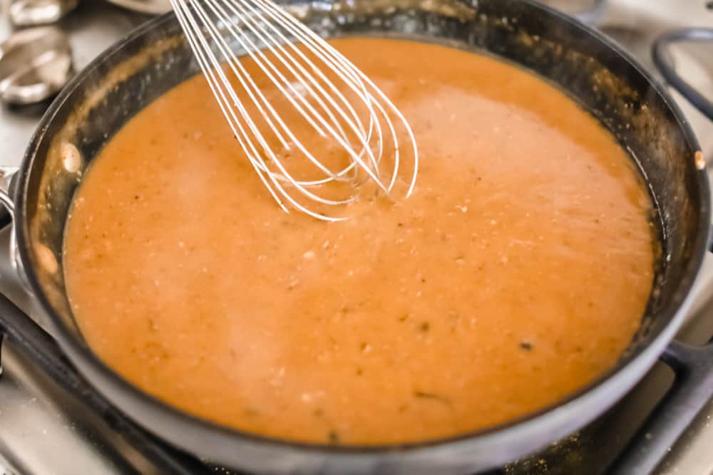 Turkey gravy whisking in a pan.