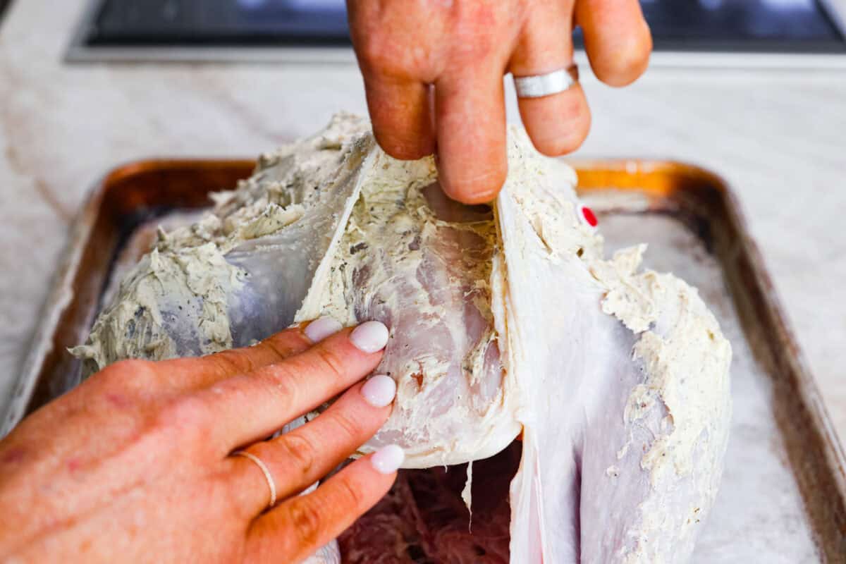 Eighth photo of the herb butter spreading underneath the skin of the turkey.