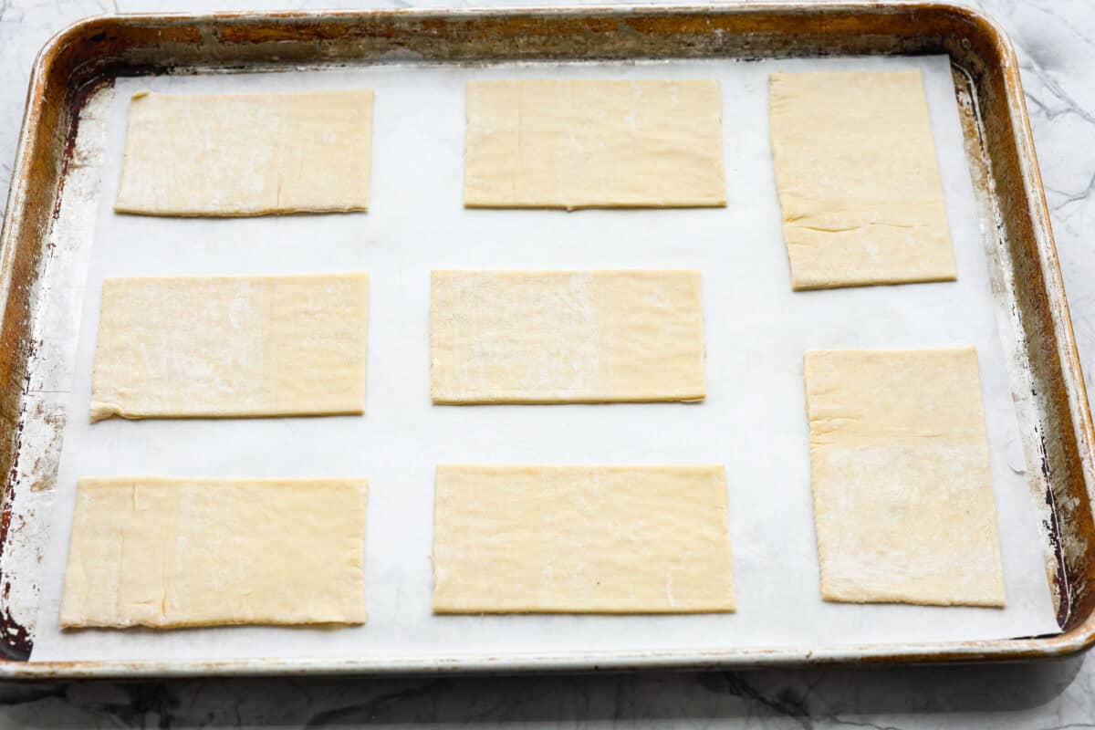 Craving the buttery goodness of a Starbucks cream cheese Danish? Now you can make it right at home! This easy copycat recipe uses flaky puff pastry and a sweet, creamy cheese filling for a treat that’s just as delicious, maybe even better! Overhead shot of puff pastry cut into rectangles and placed on a cookie sheet.