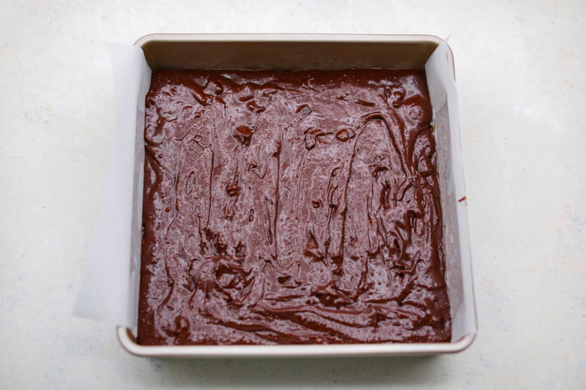 Rich, fudgy, and packed with deep chocolate flavor, Guinness Brownies are a must-try for any dessert lover! The stout beer enhances the cocoa, adding a subtle, malty depth of flavor that makes these brownies rich and irresistibly delicious. Overhead shot of Guinness brownie batter in a baking pan.