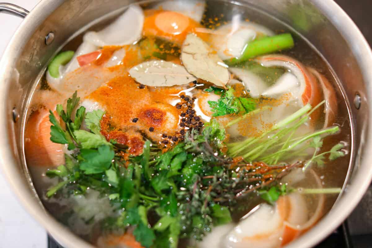 Herbs and spices added to the pot of water and veggies. 