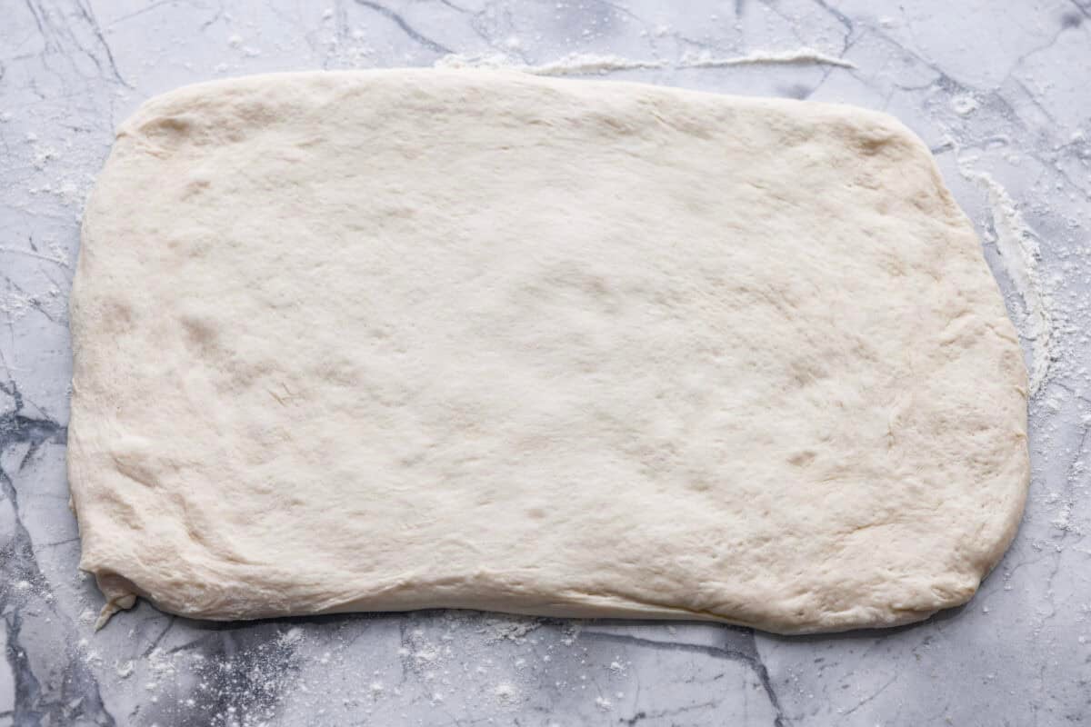 Breadstick dough rolled out onto a floured surface.