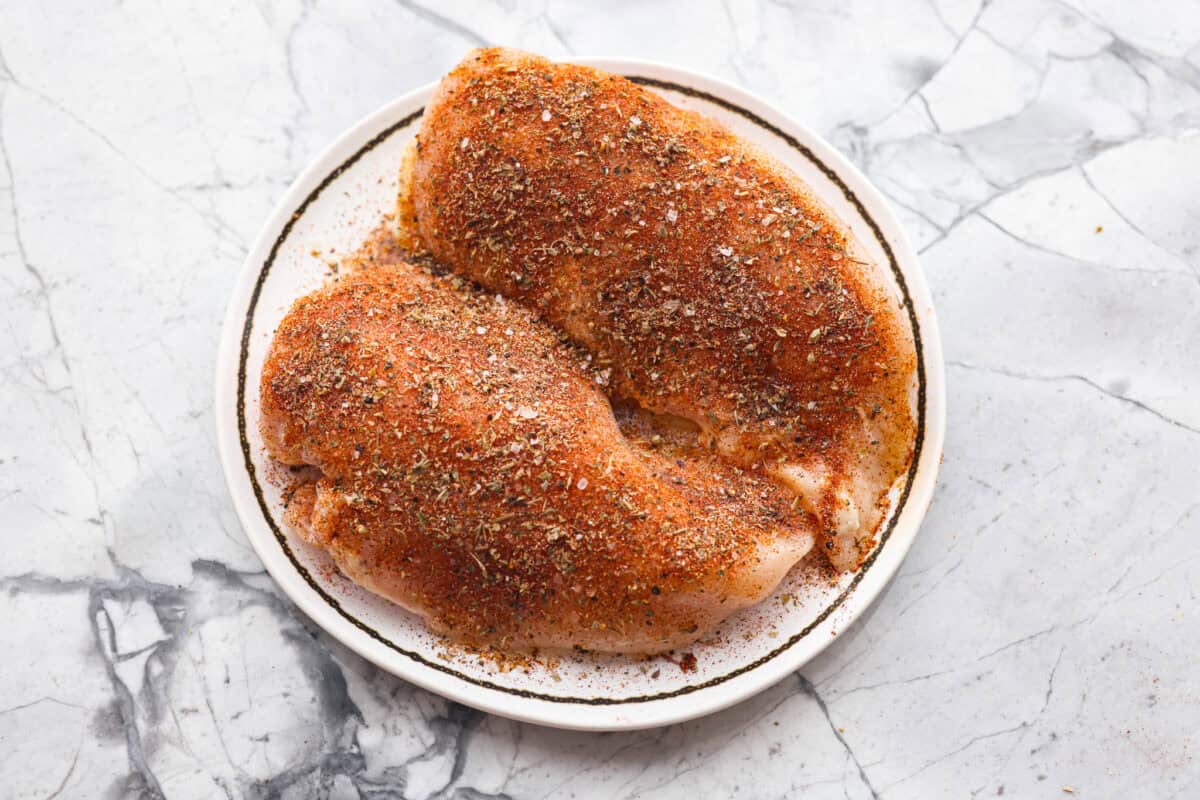 Chicken breasts covered in oil and seasoning blend. 