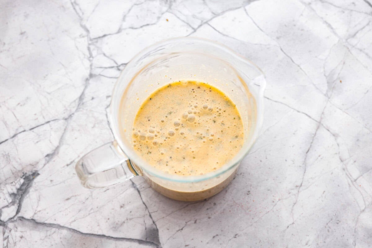 Dressing mixes with broth combined in a measuring cup. 