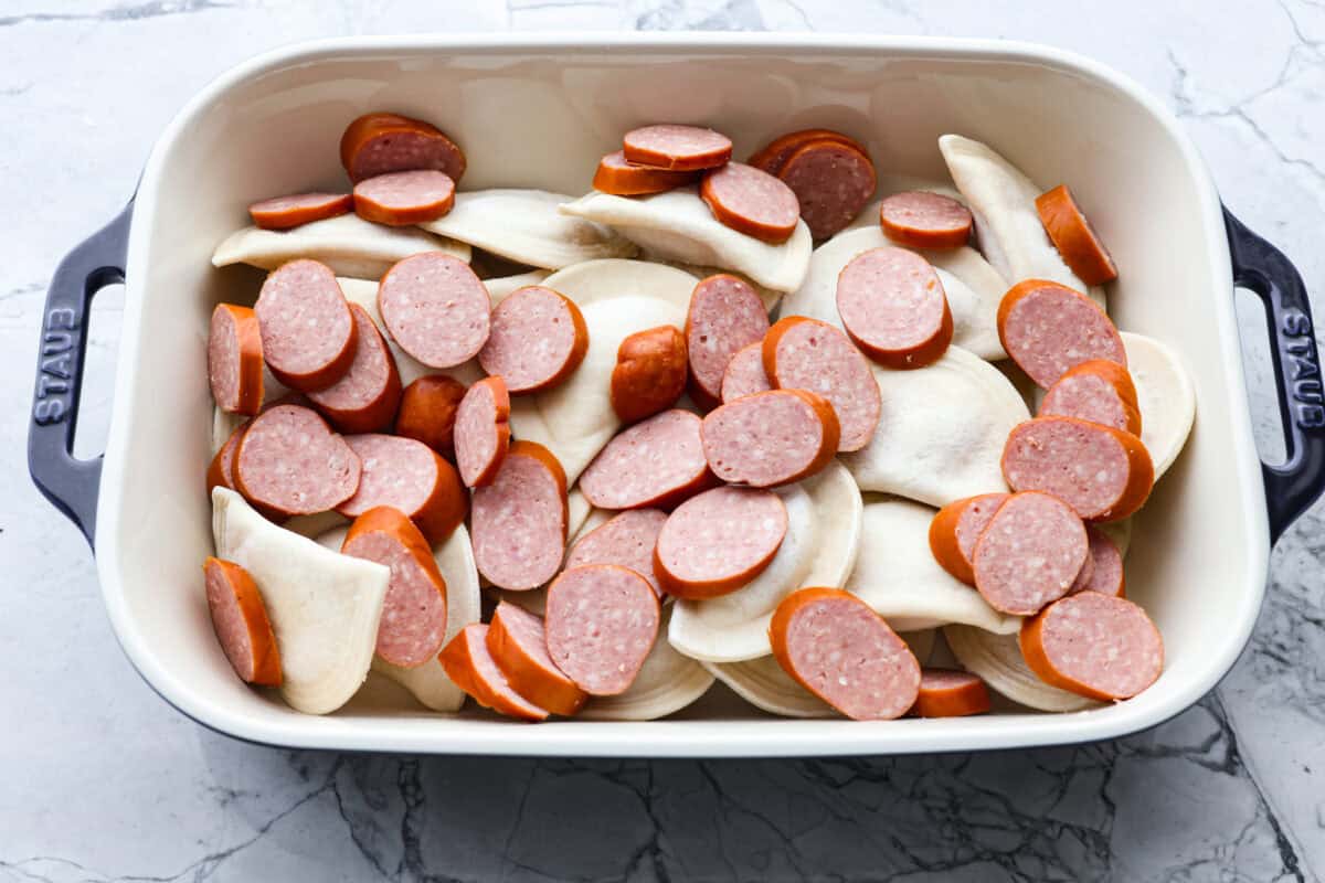 Pierogis and kielbasa sausage in the baking dish. 