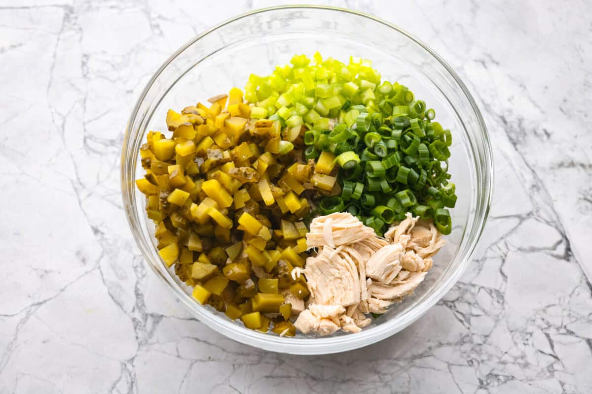 Bowl of pickles, chicken, onion and celery.