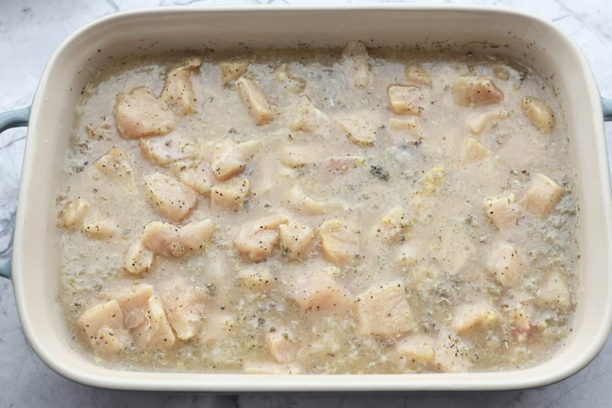 Seasoned chicken added to the baking dish. 