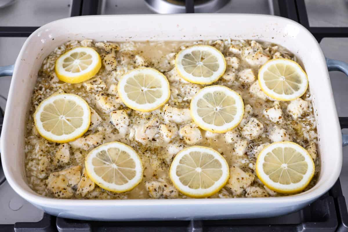 Casserole par baked with fresh lemon slices on top ready to go back in the oven to finish cooking. 