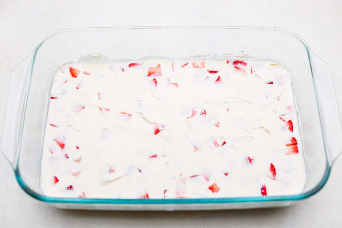 Cream cheese layer spread over strawberries and crust. 