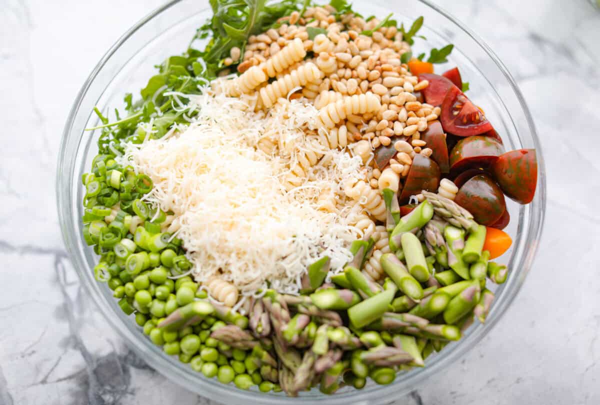 Process shot of all of the pasta salad ingredients in a large bowl. 