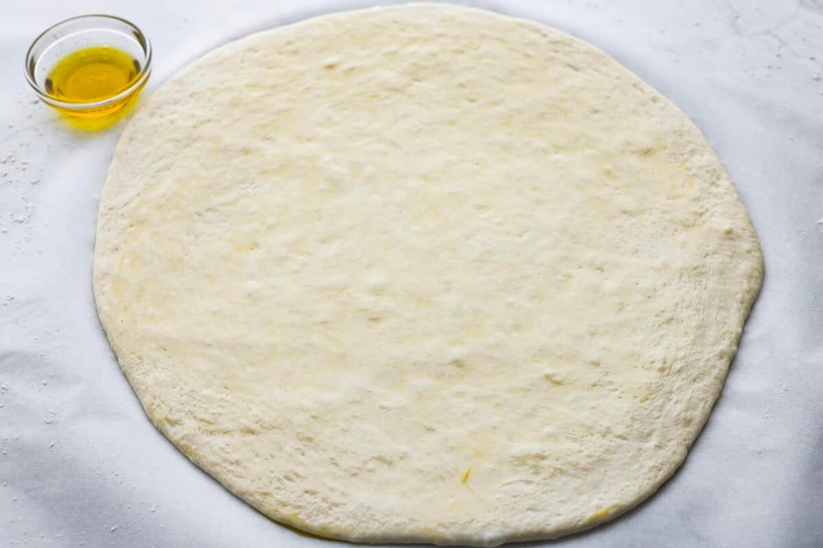 Pizza dough rolled out into a circle.