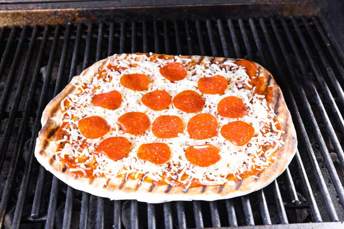 Topped pizza on top of the grill, raw side down. 