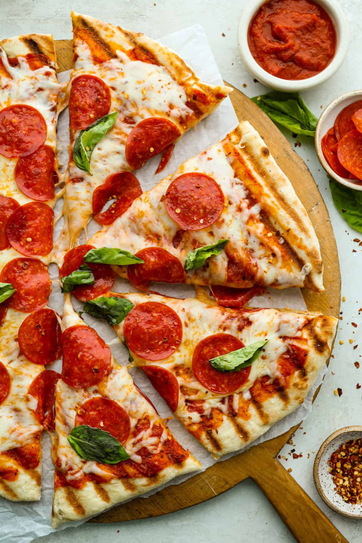 Overhead shot of grilled pizza cut into slices. 