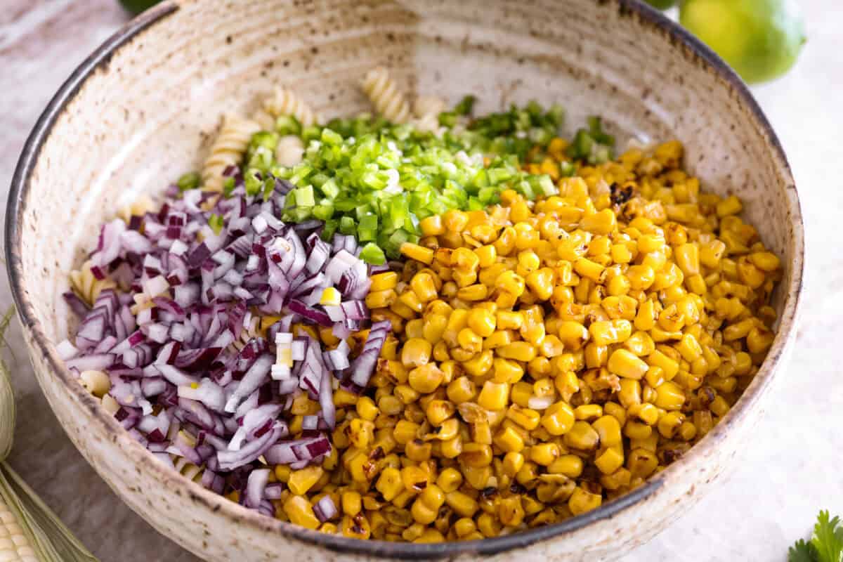 Cooked pasta with diced onion, jalapeno, and corn added to it. 