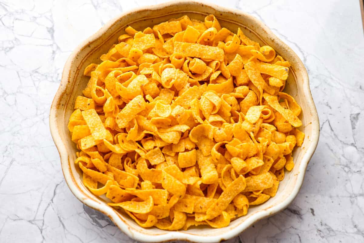 Frito chips added to the greased pie pan. 