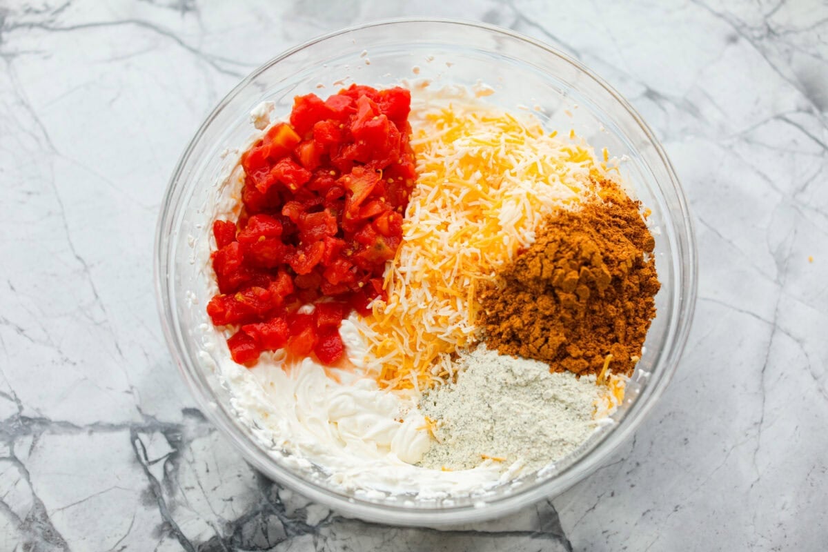 Rotel, cheddar cheese, and seasonings added to the cream cheese mixture. 