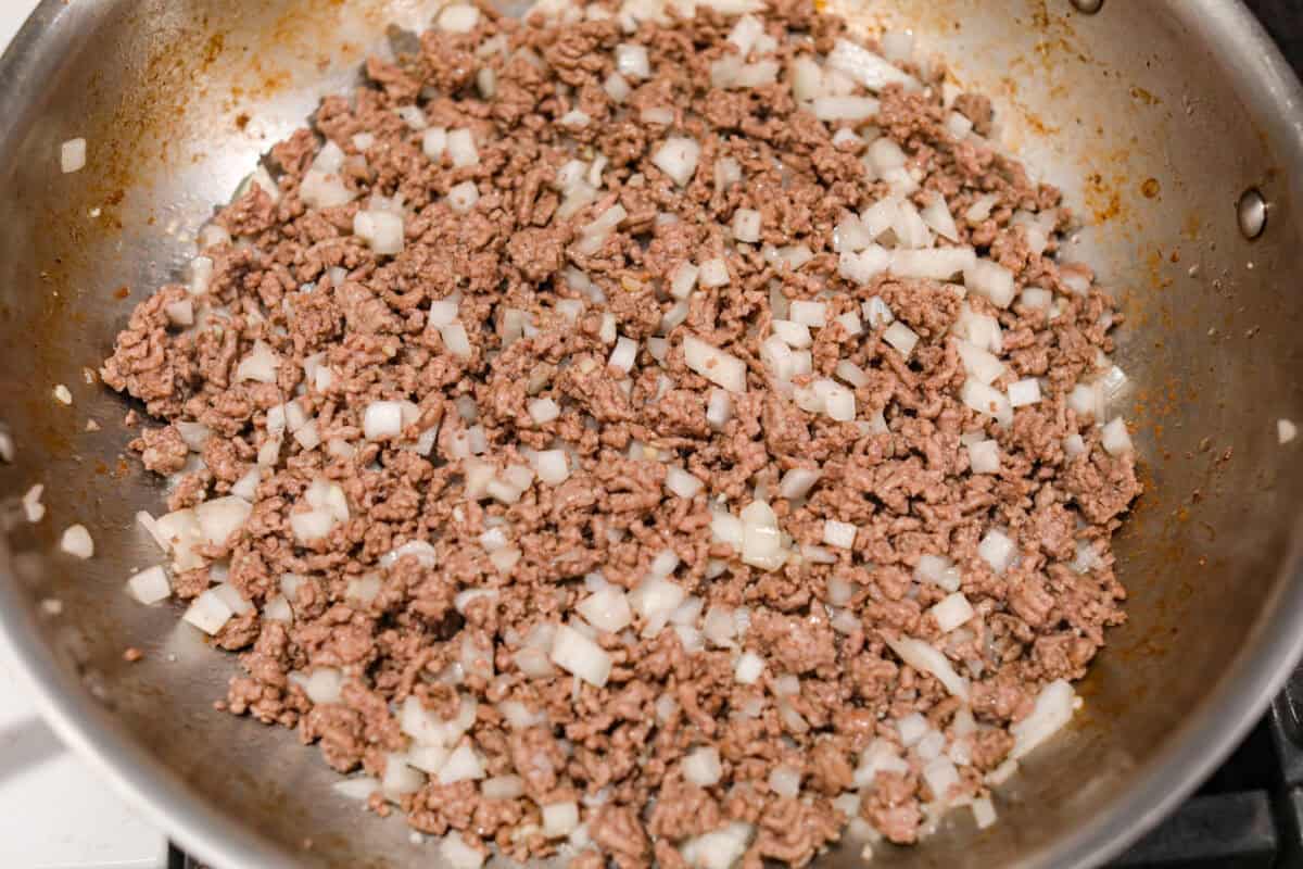 Ground beef and onion cooking in a skillet. 