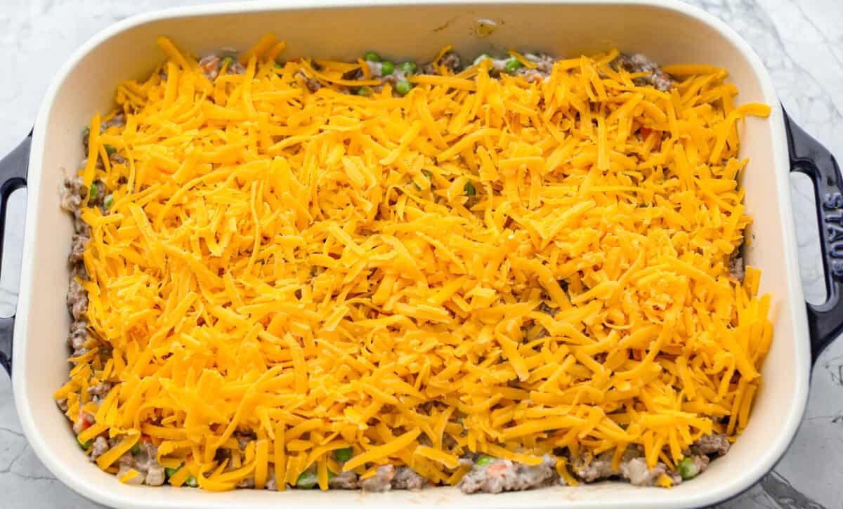 Casserole ingredients layered in a baking dish. 