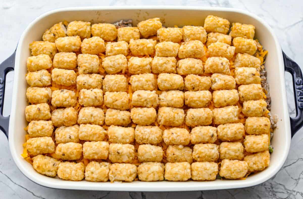 Tater tots placed on top of the layered casserole. 