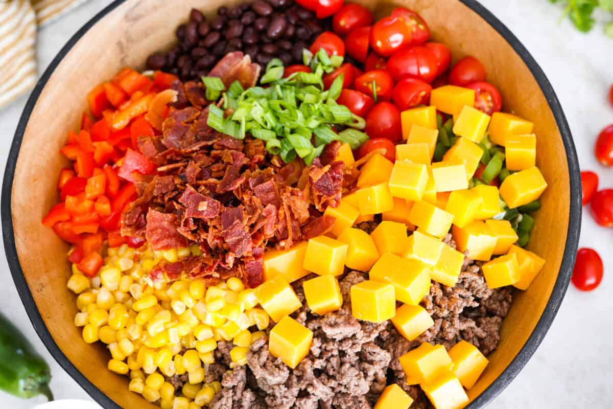 All of the pasta salad ingredients in a serving bowl. 