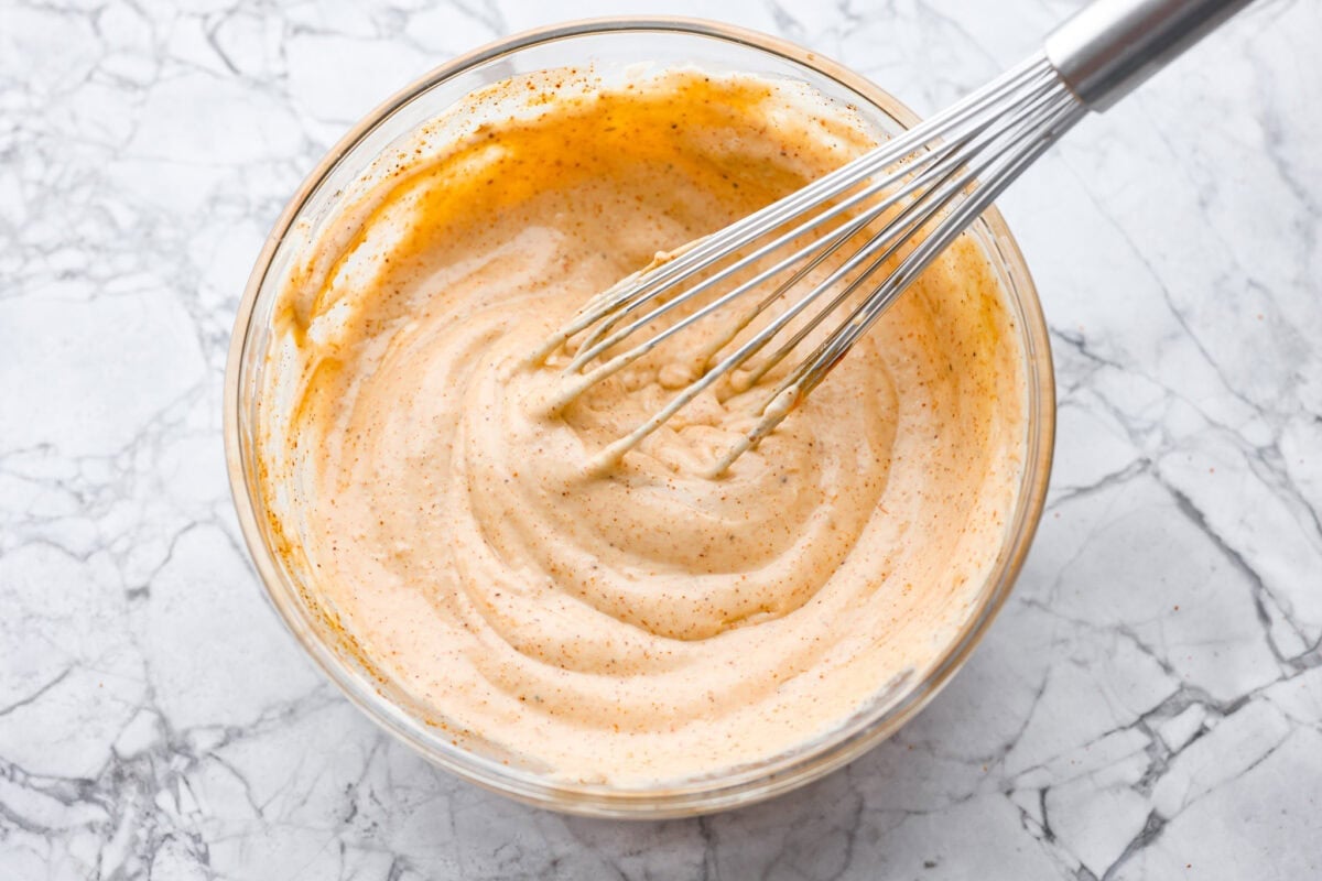 Dressing ingredients whisked together in a mixing bowl. 