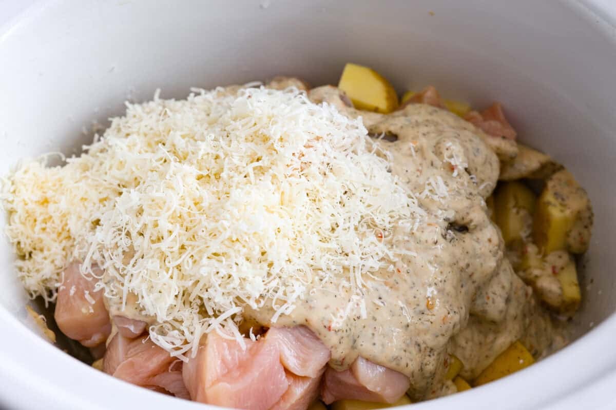 Sauce, cheese and broth added to the slow cooker. 