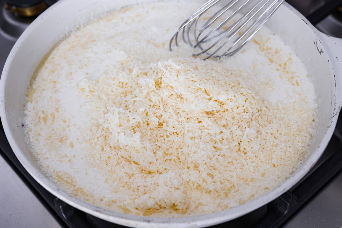 Chicken broth, heavy cream and grated parmesan cheese added to the roux to make the cream sauce. 
