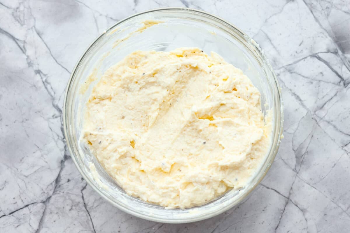 Ricotta cheese, parmesan, egg, salt, and pepper mixed together in a bowl. 