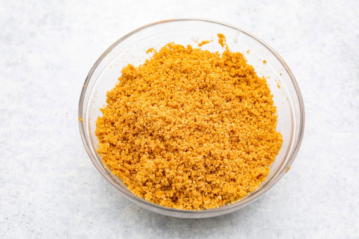 Crushed graham crackers in a bowl with sugar and melted butter. 